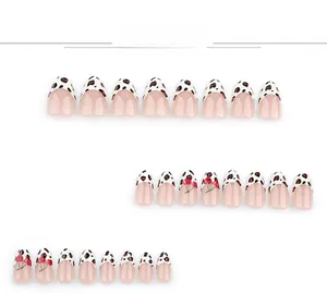 Détails de faux ongles French avec motif léopard et dessins de cerises rouges élégants