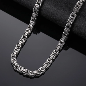 Macro shot of silver stainless steel Cuban chain showing detailed square link texture