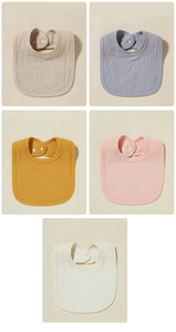 Close-up of five muslin cotton baby bibs with snap buttons in soft earthy tones