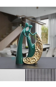 Close-up of dark green ceramic couple figurine with golden floral relief and artistic finish