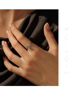 Vue macro d'une bague solitaire en moissanite taille émeraude portée sur fond texturé
