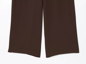 Texture détaillée du pantalon large tissé marron foncé montrant le tissu et l'ourlet
