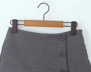 Dettaglio gonna a trapezio grigio scuro con tre bottoni e chiusura con zip laterale