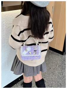 Detail of purple tweed girl's bag featuring pearl handle and rhinestone bear ornament