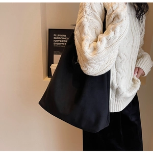 Large black suede tote bag styled with a white knit sweater for an autumn office look