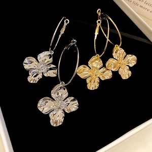 Dettaglio orecchini a cerchio a forma di fiore metallico con petali in oro e argento
