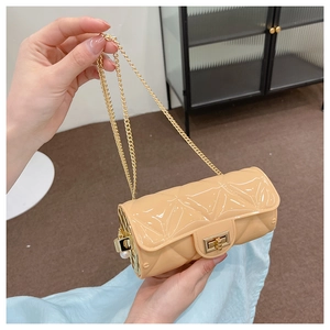 Detail of beige quilted cylindrical bag with gold chain strap and pearl accent
