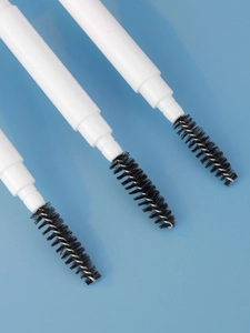 Three disposable spoolie brushes for eyelashes and brows on a blue background