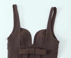 Detail of dark brown mini dress featuring a sweetheart neckline and flat bow ornament