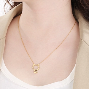 Close-up of minimalist gold cat outline pendant necklace worn on a female model