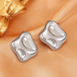 Modern molten texture silver heart earrings on elegant orange satin silk background