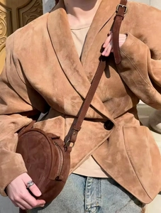 Close-up of the premium brown suede texture on a vintage style blazer and round crossbody bag