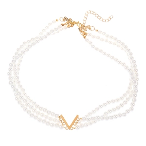 Parure collier perles à trois rangs avec pendentif en V doré sur fond blanc pur