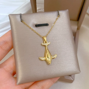 Detailed close-up of a 3D gold whale pendant necklace featuring sparkling zircon accents