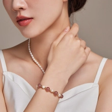 Detail of freshwater pearl and purple stone beaded bracelet with golden spacers on wrist