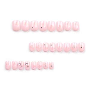 Faux ongles rose dégradé avec motifs cœur, strass et étoiles sur fond blanc pur