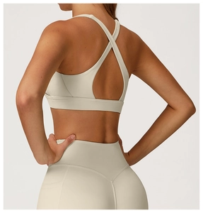 Detailed back view of beige yoga bra with cross straps and high waist leggings set
