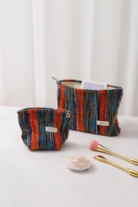 Detail of bohemian knit makeup bag set with colorful striped texture and zip closure