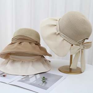 Détail d'un chapeau de soleil élégant avec grand nœud et texture paille et tissu