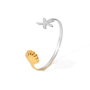 Detailed shot of two-tone open bangle with silver starfish and gold shell charms