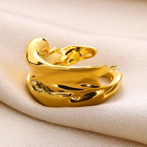 Macro shot of irregular lava texture and organic fluid gold finish on the open ring