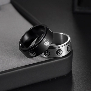 8mm stainless steel rotatable tai chi rings in black and silver finishes on a gray box
