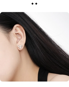 Detail view of irregular S925 silver stud earring with cubic zirconia on model's ear