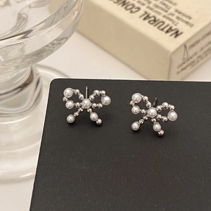 Détail de boucles d'oreilles nœud papillon en perles sur carte de présentation noire