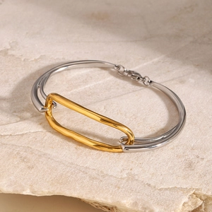 Detailed close-up of mixed-tone geometric 18k stainless steel bracelet on stone background