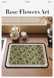 Close-up of a green floral dish drying mat with rose patterns on a wooden countertop