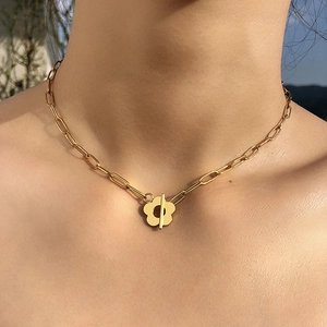 Detail of gold flower pendant necklace with rectangle links and T-bar toggle clasp