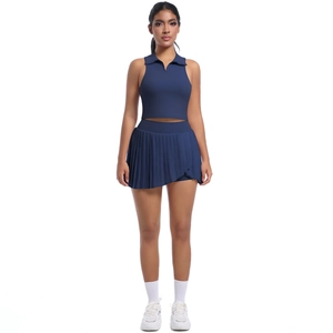 Détail du haut polo sans manches bleu marine et de la jupe de sport plissée taille haute