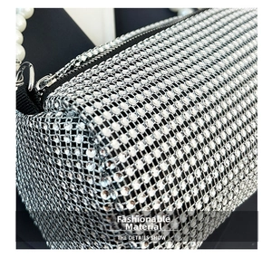 Dettaglio degli strass argentati e del manico di perle di una borsa a cilindro