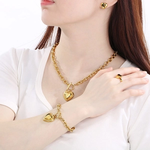 Golden heart-shaped stainless steel jewelry set featuring necklace, bracelet, and earrings