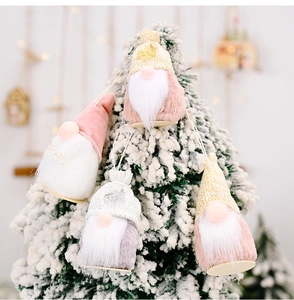 Nahaufnahme von vier Plüsch-Weihnachtswichteln an einem verschneiten Weihnachtsbaum