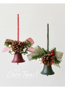 Detail of red and green metal Christmas bells with pine cones and berries