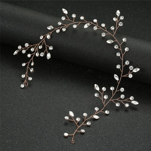 Detailed view of rose gold bridal hairpiece with marquise crystals on black background