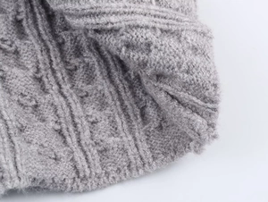 Primer plano de tejido de punto trenzado gris con textura de lana suave