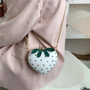 Cute strawberry shaped white crossbody bag with gold studs and a metal chain strap