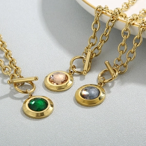 Macro view of gold OT buckle necklaces with green, champagne and grey crystal pendants