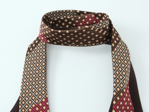 Macro shot of geometric diamond pattern scarf with brown and pink silk-like fabric detail