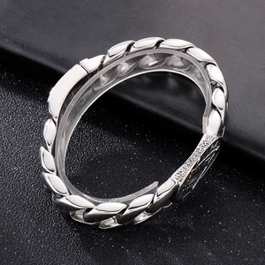 Macro shot of silver punk-style chain bracelet with detailed round relief buckle clasp