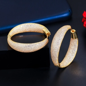 Detailed close-up of wide gold-plated hoop earrings with micro-pave white zircon stones