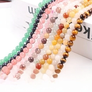 Detailed view of polished natural gemstone beads including agate, quartz and tiger eye