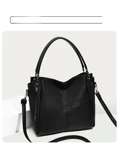 Macro detail of black litchi grain leather bag with cross stitching and side metal zipper