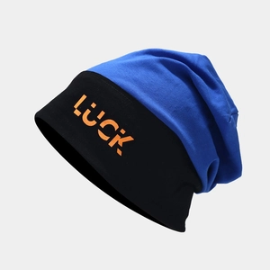 Detailed close-up of a blue and black knit beanie featuring Luck orange lettering