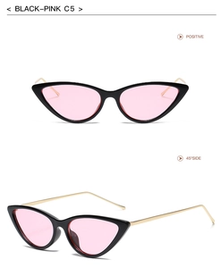 Detail view of cat eye sunglasses with black frames, pink lenses and gold metal temples