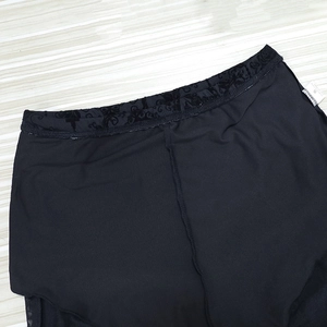 Detail of high waist elastic band with flocked pattern and size S label on black trousers