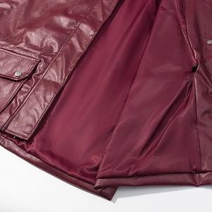 Detail of burgundy PU leather jacket featuring reinforced stitching and metallic snap buttons
