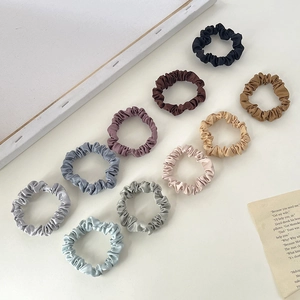 Set of 10 multicolor satin hair scrunchies in elegant neutral tones on white background